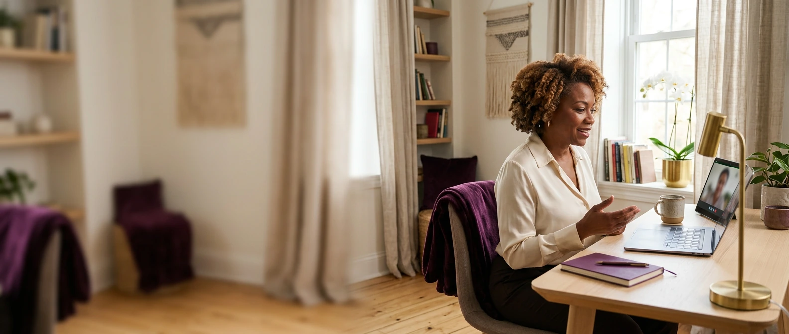 Warm virtual coaching session with Sharon on a laptop video call in a calm home workspace, framed with clean space for the FAQ heading.